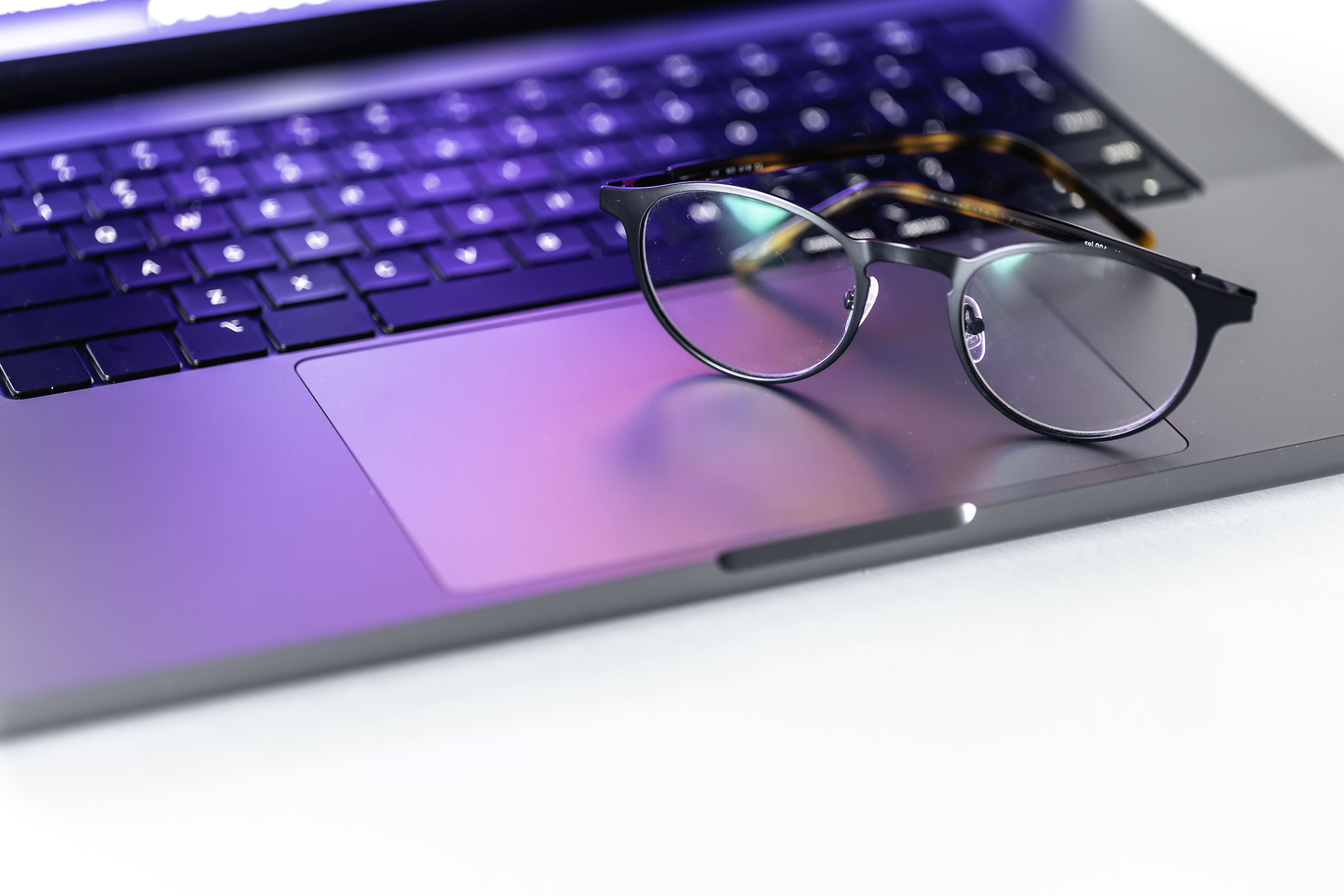 Persona trabajando frente a una computadora con lentes de filtro azul